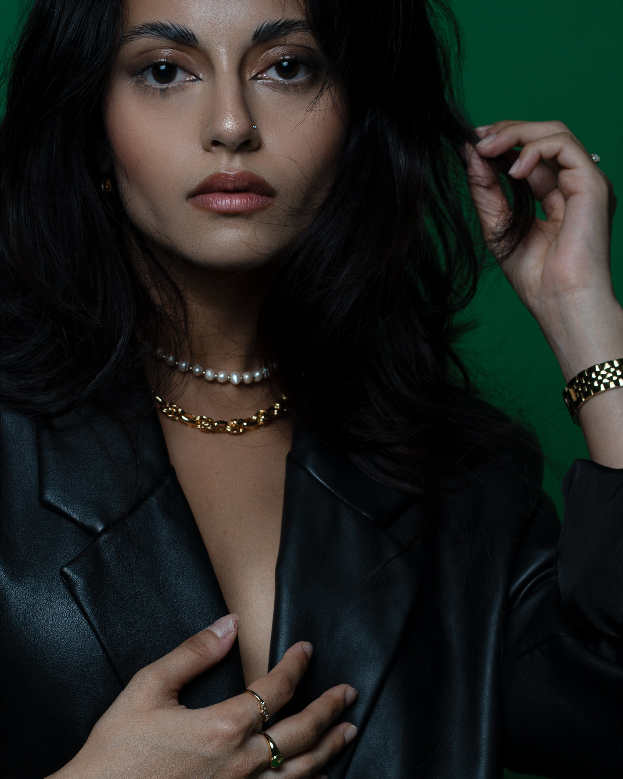Editorial close-up — green backdrop leather jacket