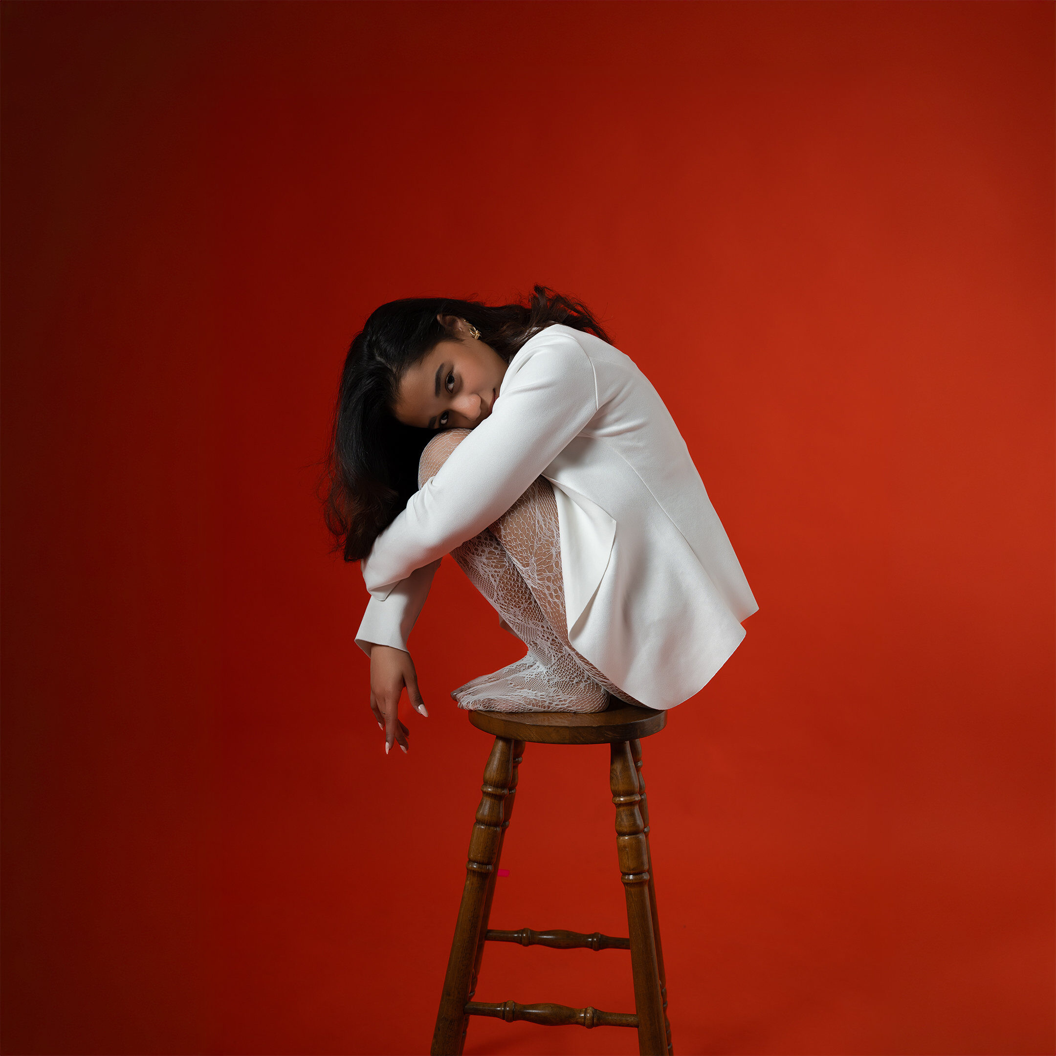 Studio portrait — red backdrop white blazer