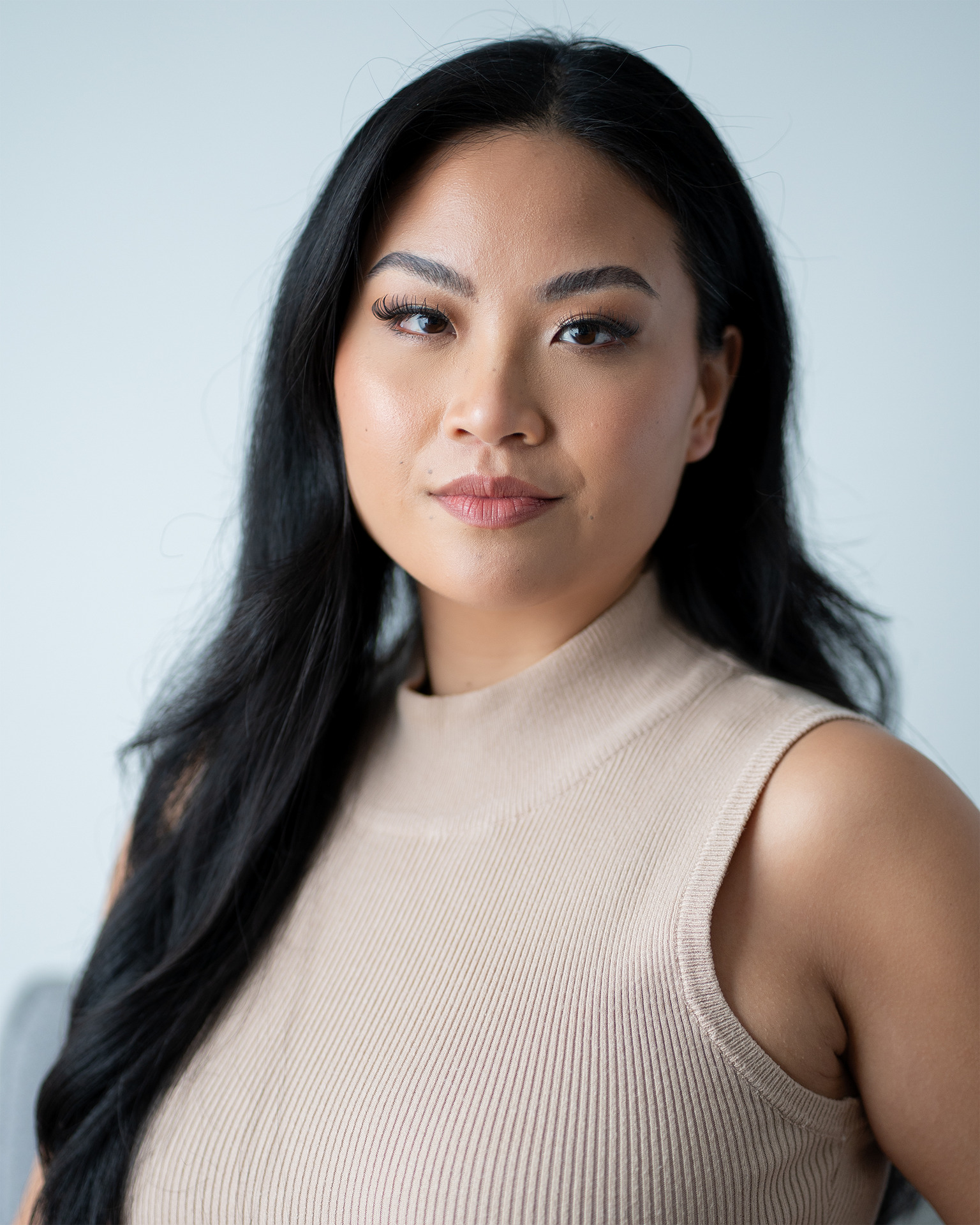 Model headshot — beige ribbed top serious