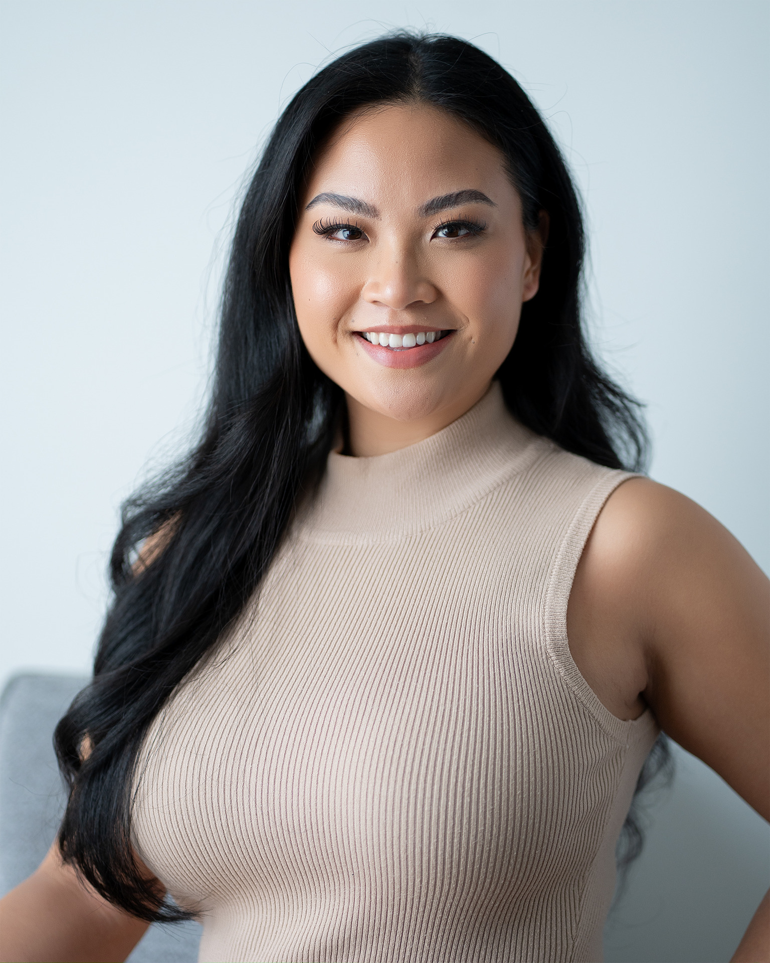 Model headshot — smiling beige ribbed top