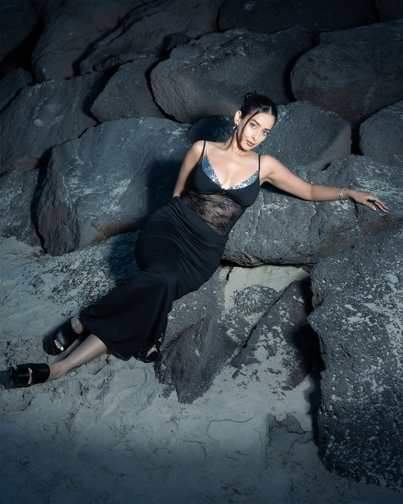 Outdoor editorial — reclining on coastal rocks at night