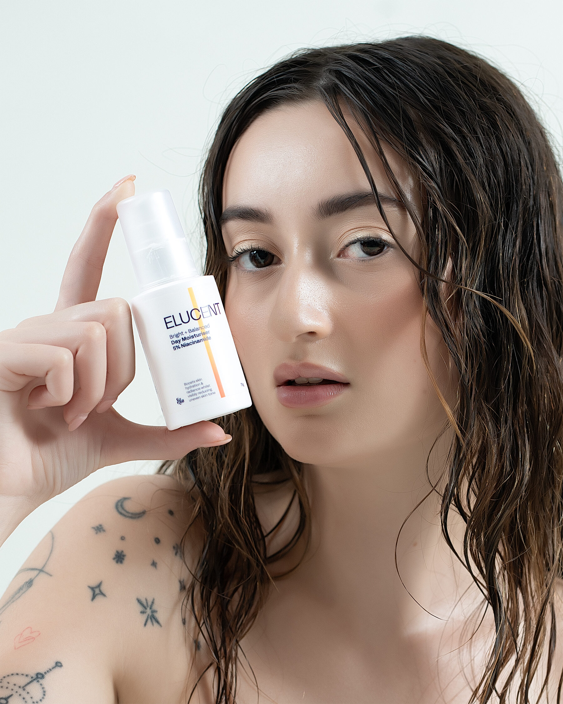 Elucent Day Moisturiser — moody editorial, product at chin