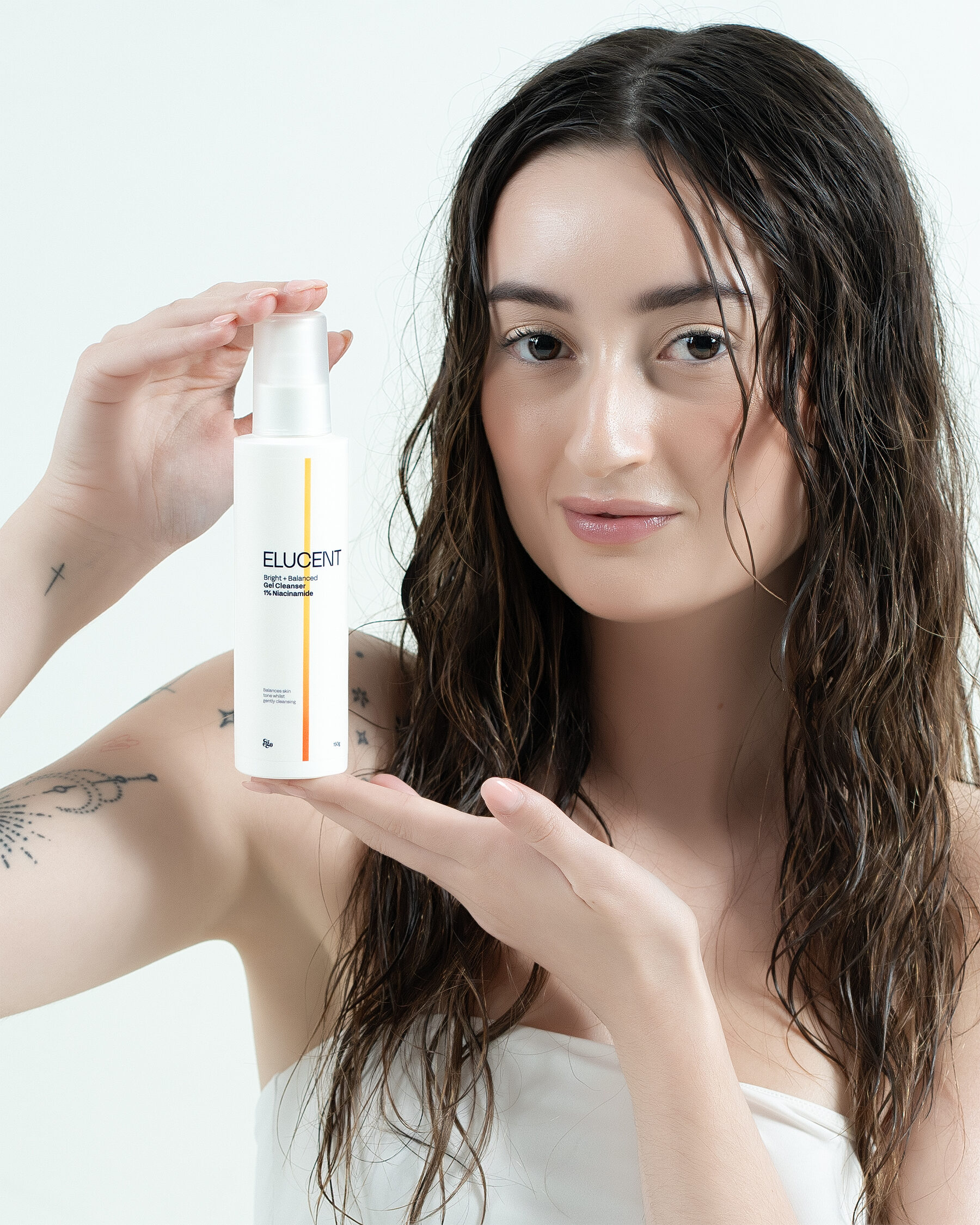 Elucent Gel Cleanser — model smiling, raised pump bottle