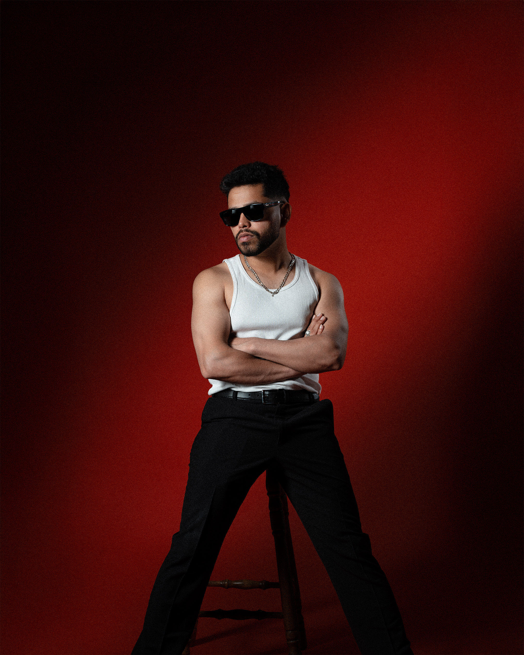 Male portrait — red backdrop arms crossed